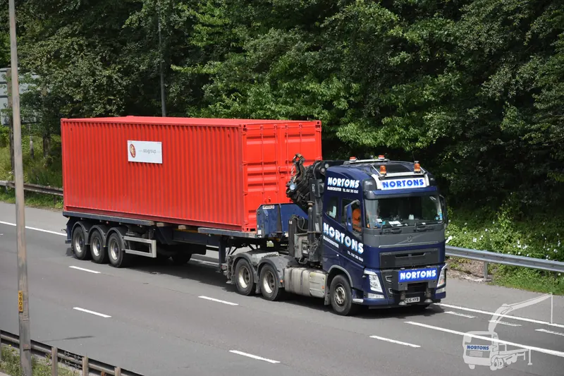 Hiab lorry transporting a shipping container along the motorway