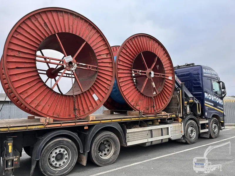 Hiab lorry delivering large cable drums on a flatbed trailer