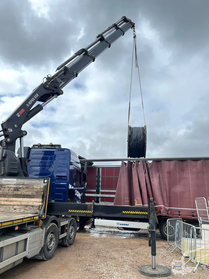 Hiab lorry delivering steel beams to a construction site