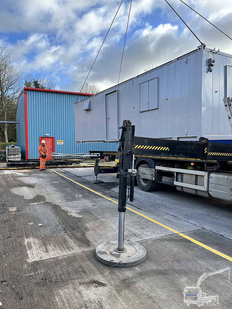 Hiab lorry lifting a cabin into a yard near Preston