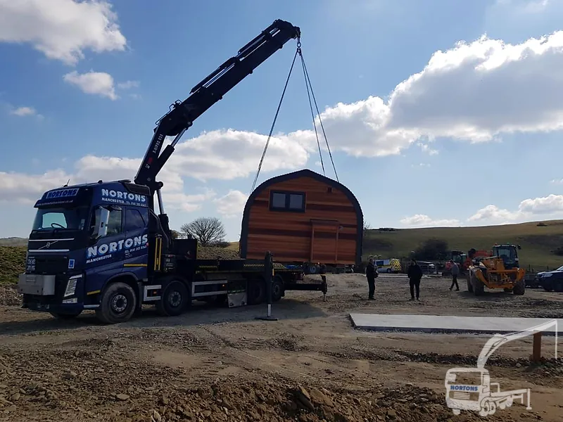 Portable cabin delivery - hiab lorry placing a site cabin into position