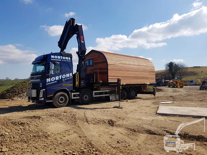 Hiab lorry transporting a cabin on a UK road — hiabtruckhire.co.uk