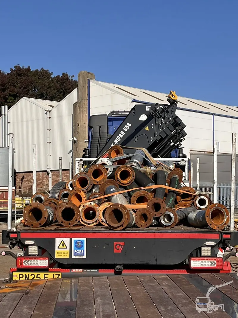 Concrete pipe sections loaded for hiab haulage with marker board