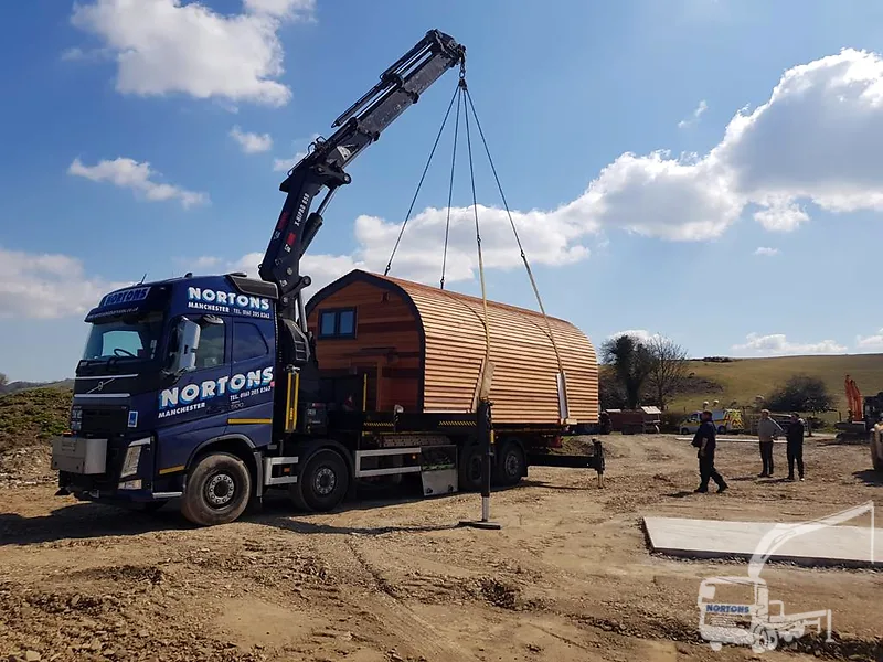 Hiab lorry lifting a timber pod on a rural Welsh site