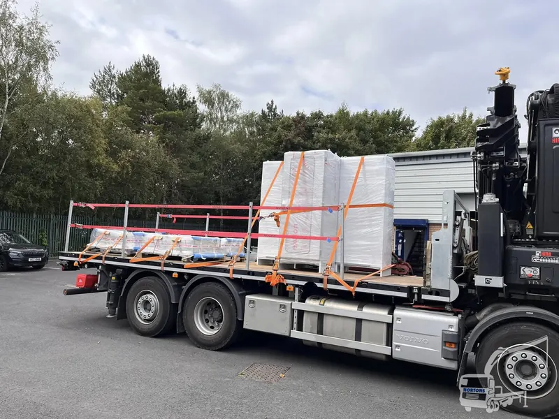 Long timber poles transported on a hiab flatbed truck