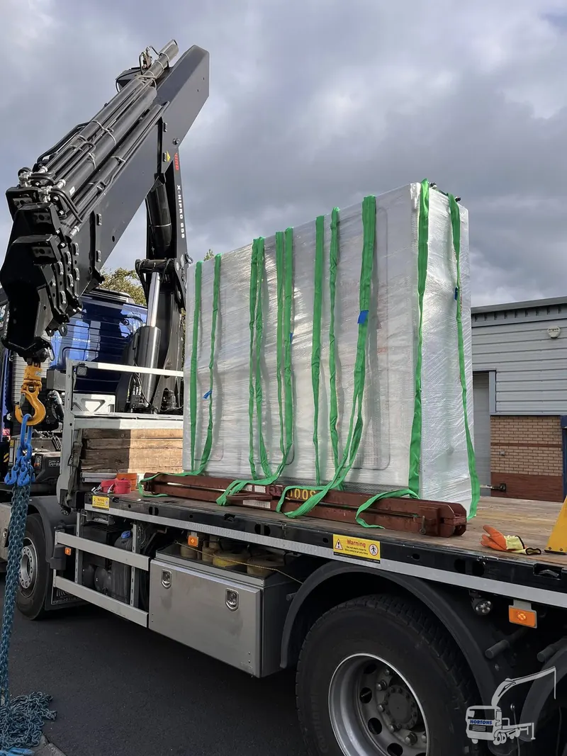 Packaged building panels loaded on a hiab flatbed