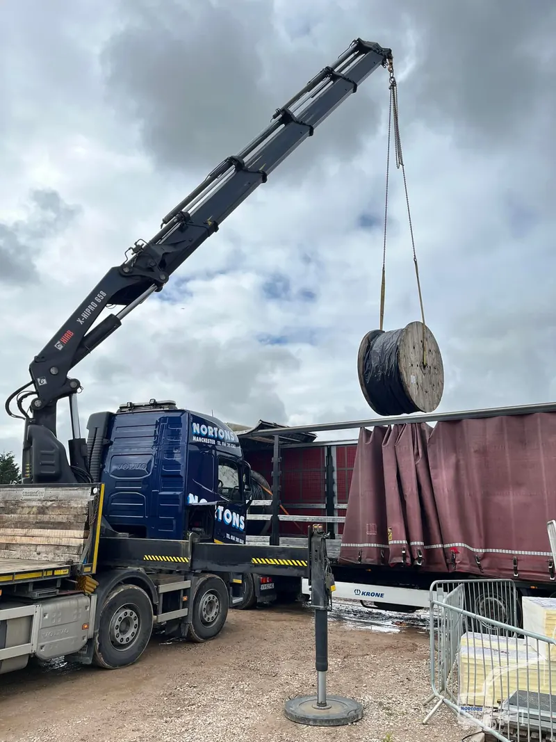 Lorry mounted crane lifting a concrete ring section