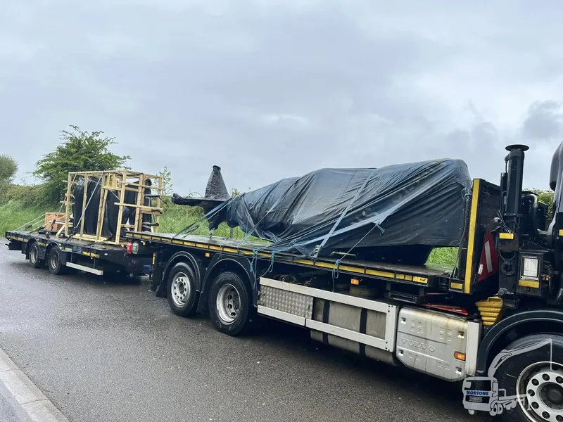 Plant machinery sheeted and secured on a low loader