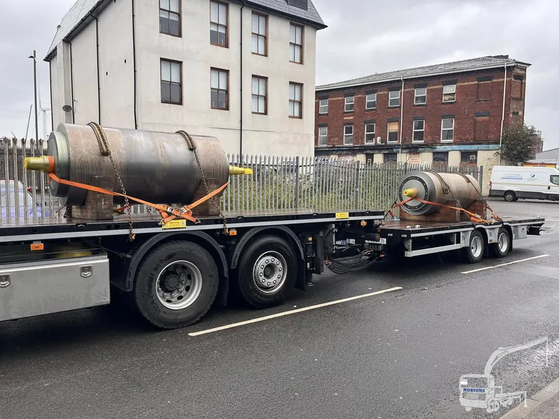 Truck with crane delivering timber and boards to a building project